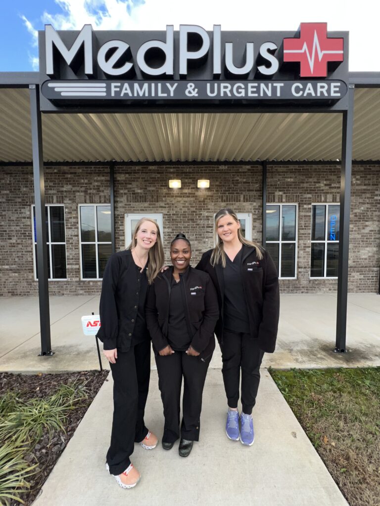 Three women standing in front of a hospital.