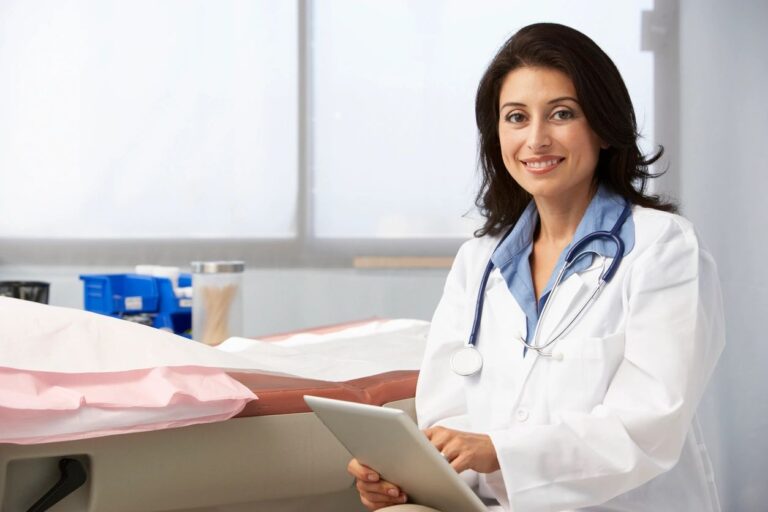 A woman in white coat holding a tablet.