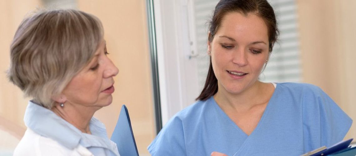 A Woman in an Overcoat Talking to Another in Scrubs